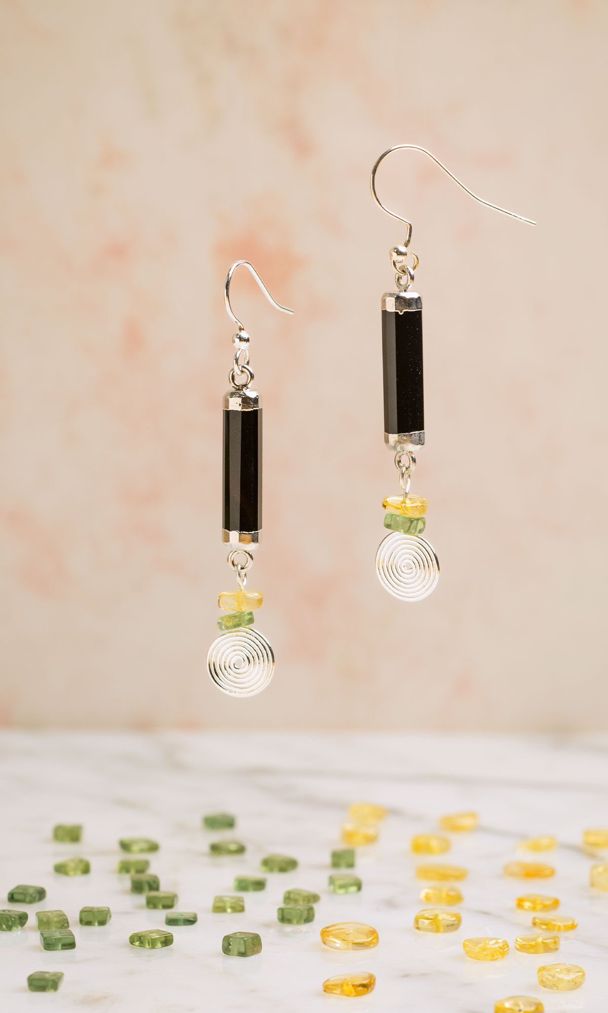 Styled photo of design idea S A 2 D with gemstones beads scattered on marble stone
